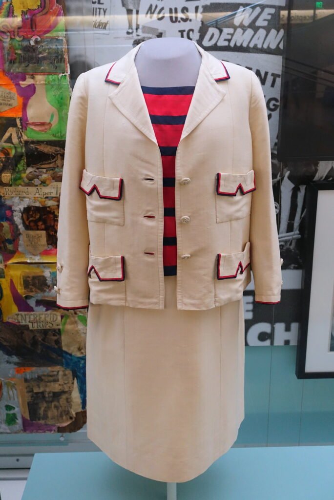 Conjunto de tres piezas de Coco Chanel de comienzos de la década de 1960, con chaqueta clara ribeteada, top de rayas y falda.