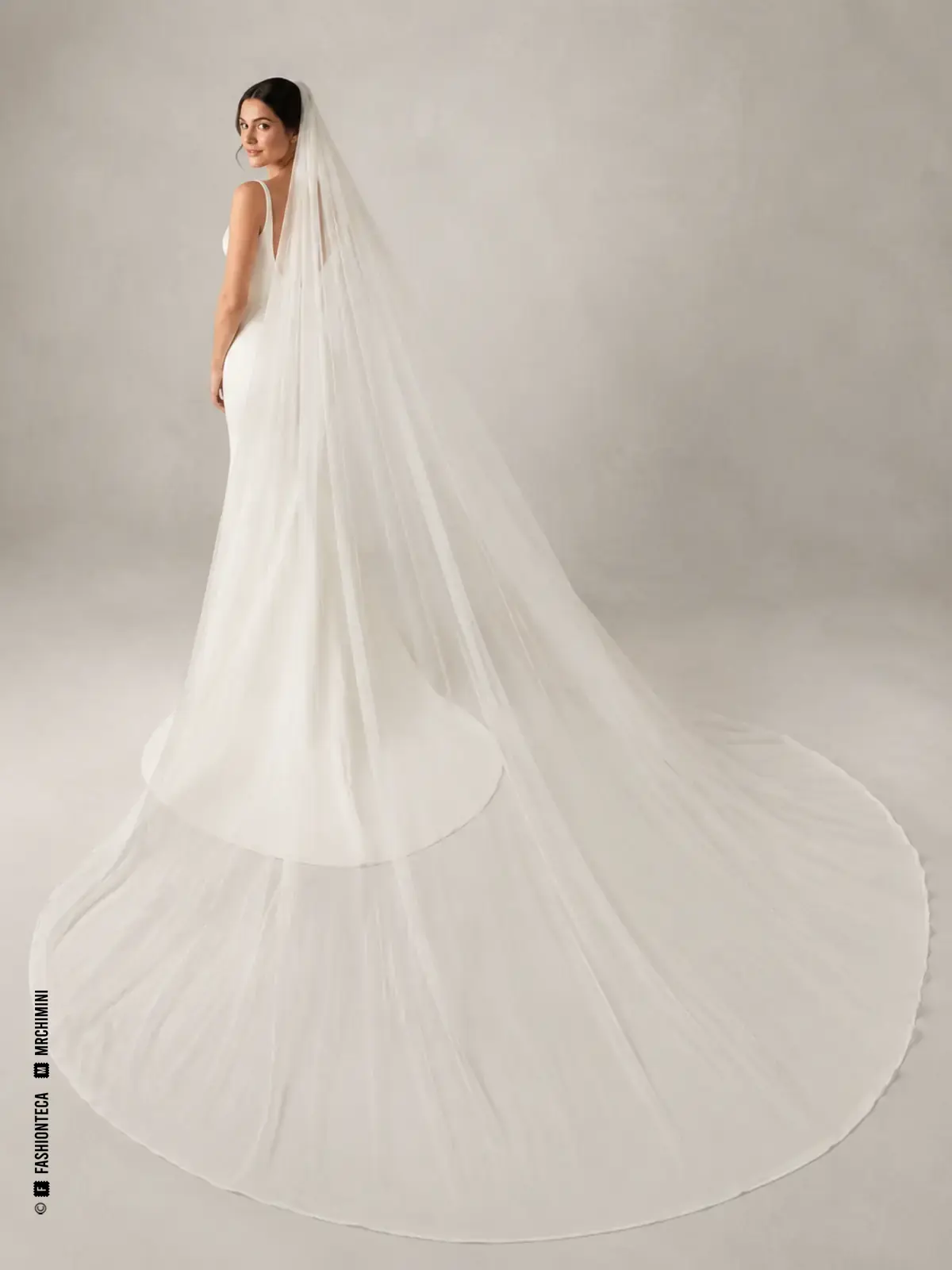 Novia con velo catedral blanco de gran longitud extendido ampliamente por el suelo.