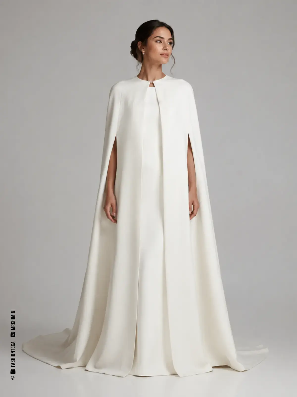 Novia con capa blanca larga y amplia, sin mangas, sobre vestido nupcial sencillo.
