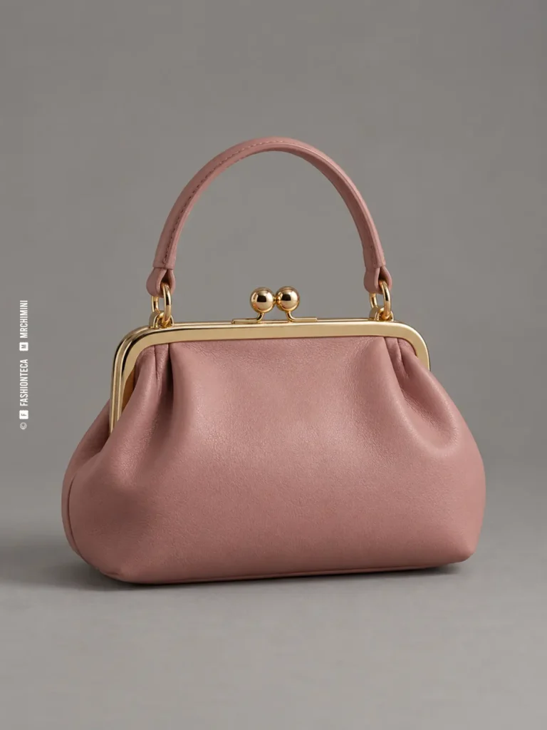 bolso de marco rosa empolvado fotografiado en estudio sobre fondo gris, con boquilla dorada y cierre kiss-lock