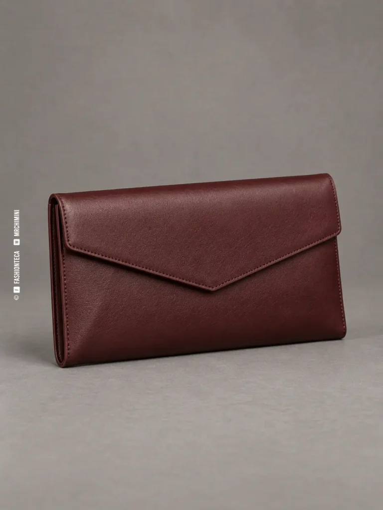 clutch sobre de piel burdeos fotografiado en estudio sobre fondo gris, sin asa y con solapa triangular