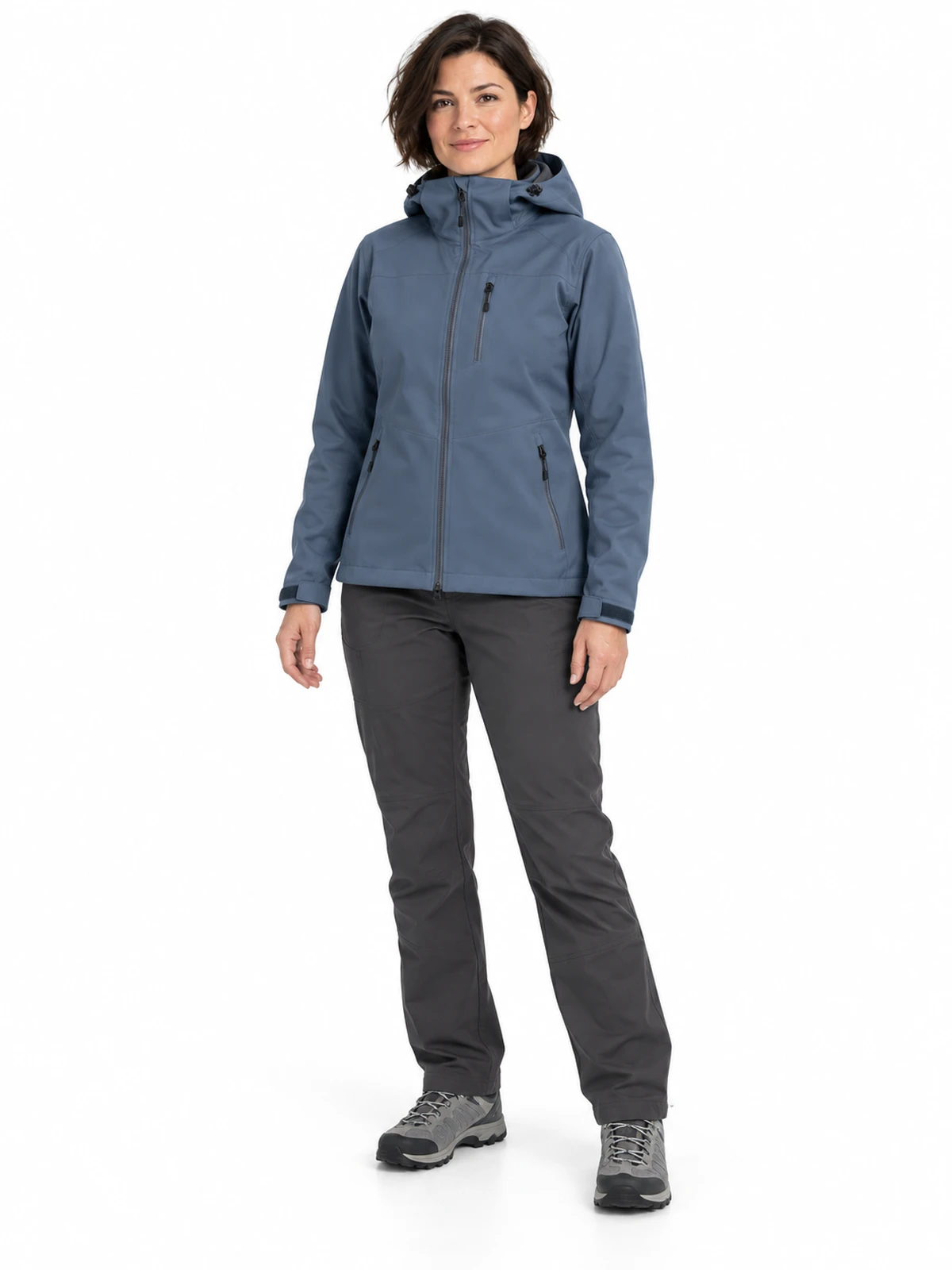 Modelo adulta con chaqueta softshell azul grisácea, capucha y bolsillos con cremallera, fotografiada de cuerpo entero sobre fondo blanco.