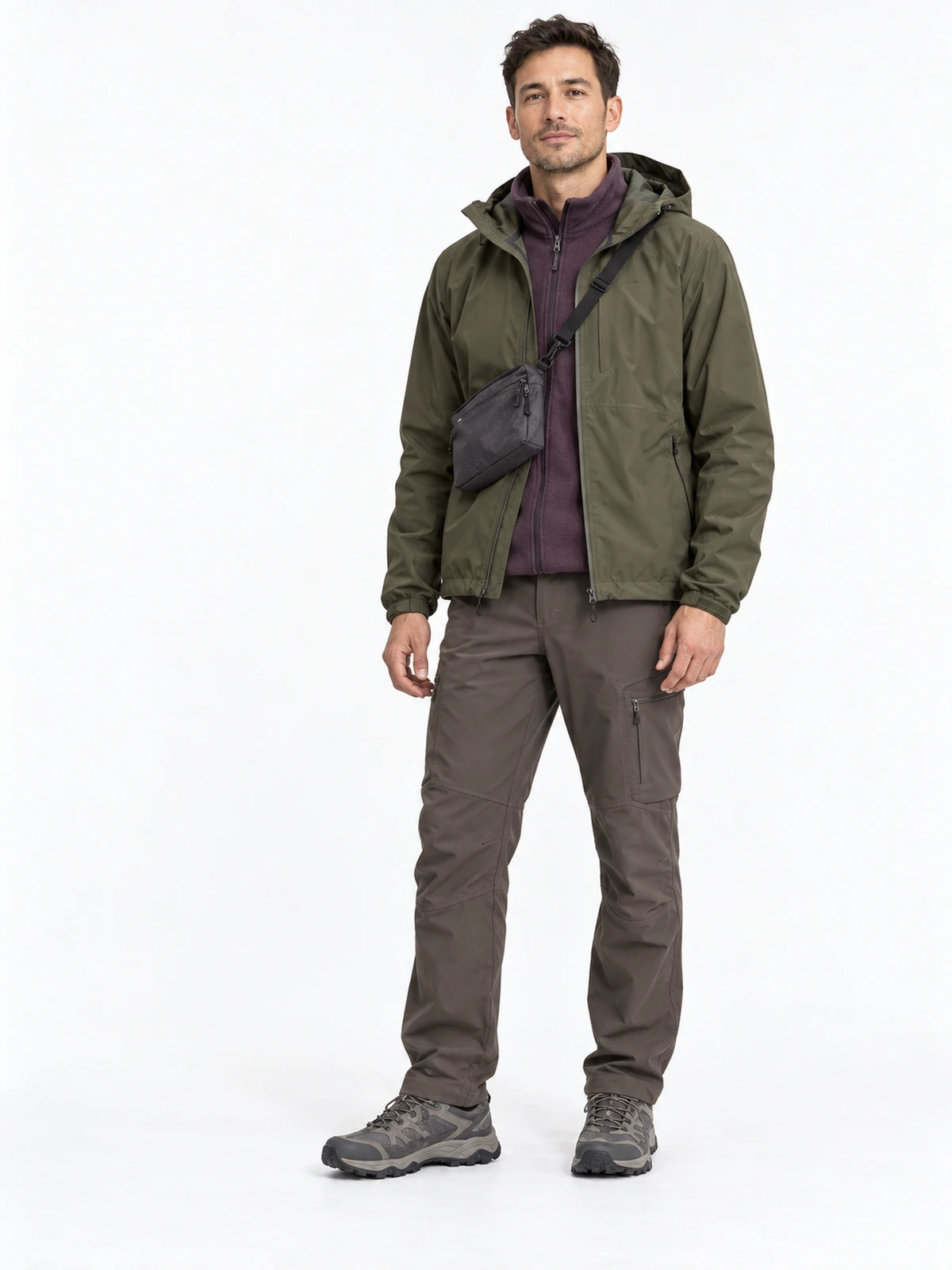 Persona adulta con conjunto urbano de inspiración outdoor: chaqueta oliva, forro polar ciruela, pantalón topo y zapatillas de trail, sobre fondo blanco.