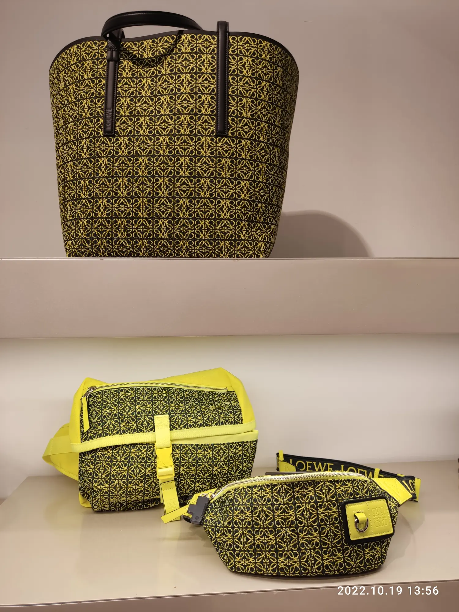 Bolsos Loewe negros y amarillos con patrón Anagram expuestos en tienda
