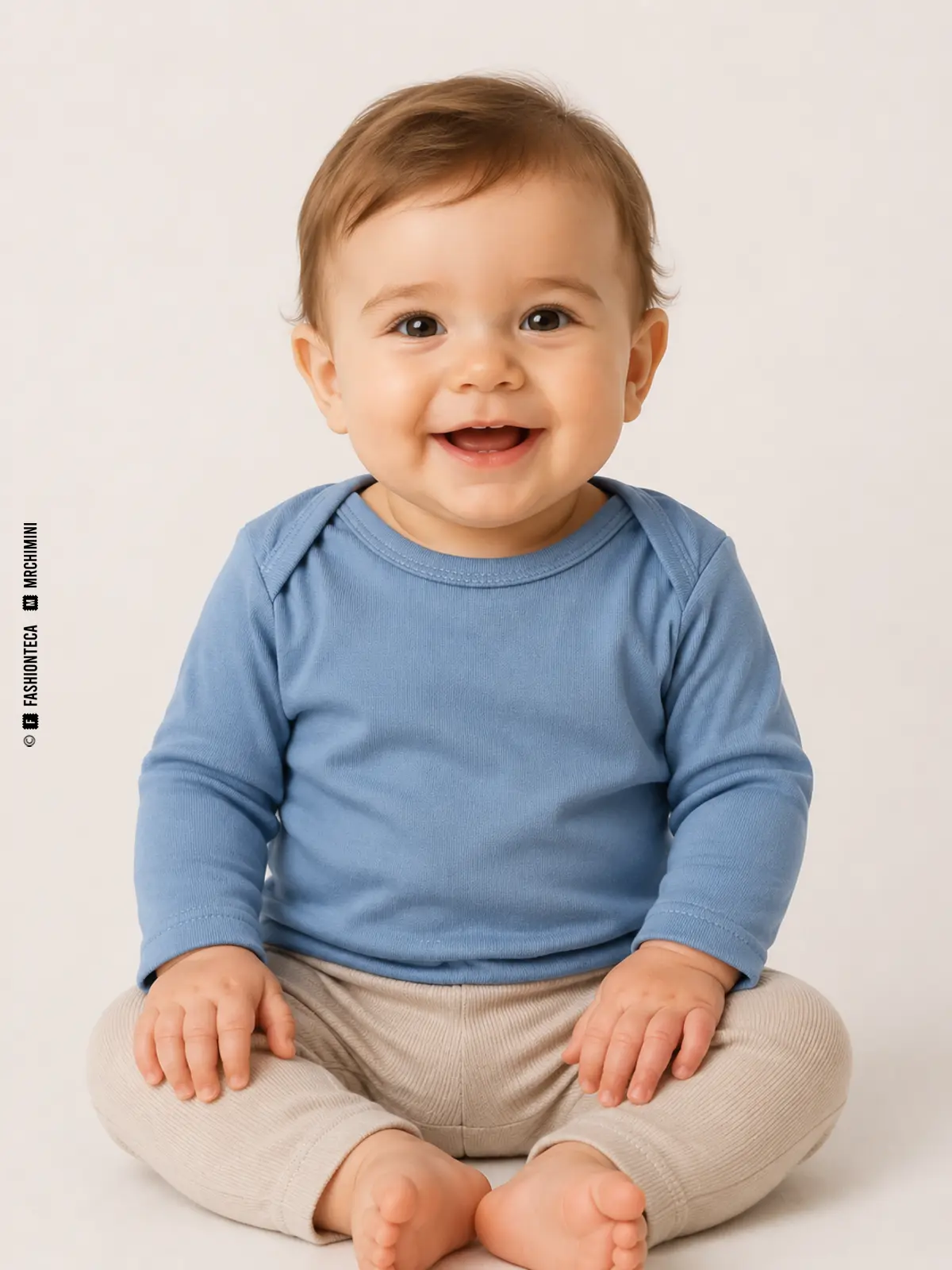 bebé sentado con camiseta azul de hombro americano y pantalón beige